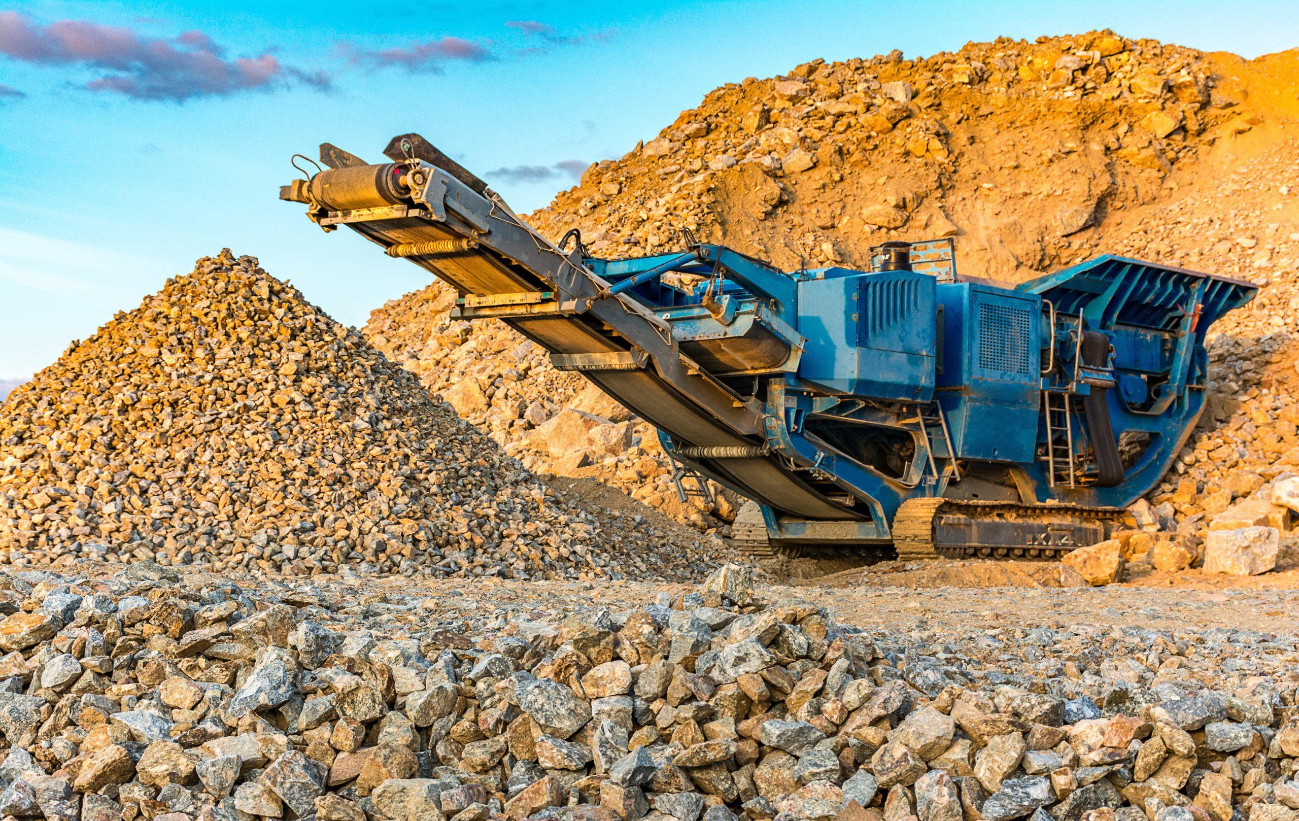 Eine große Fördermaschine auf einer Baustelle mit vielen Steinen muss für ihre schwere Arbeit mit Universal Schmierfett versorgt werden, um zuverlässig zu laufen