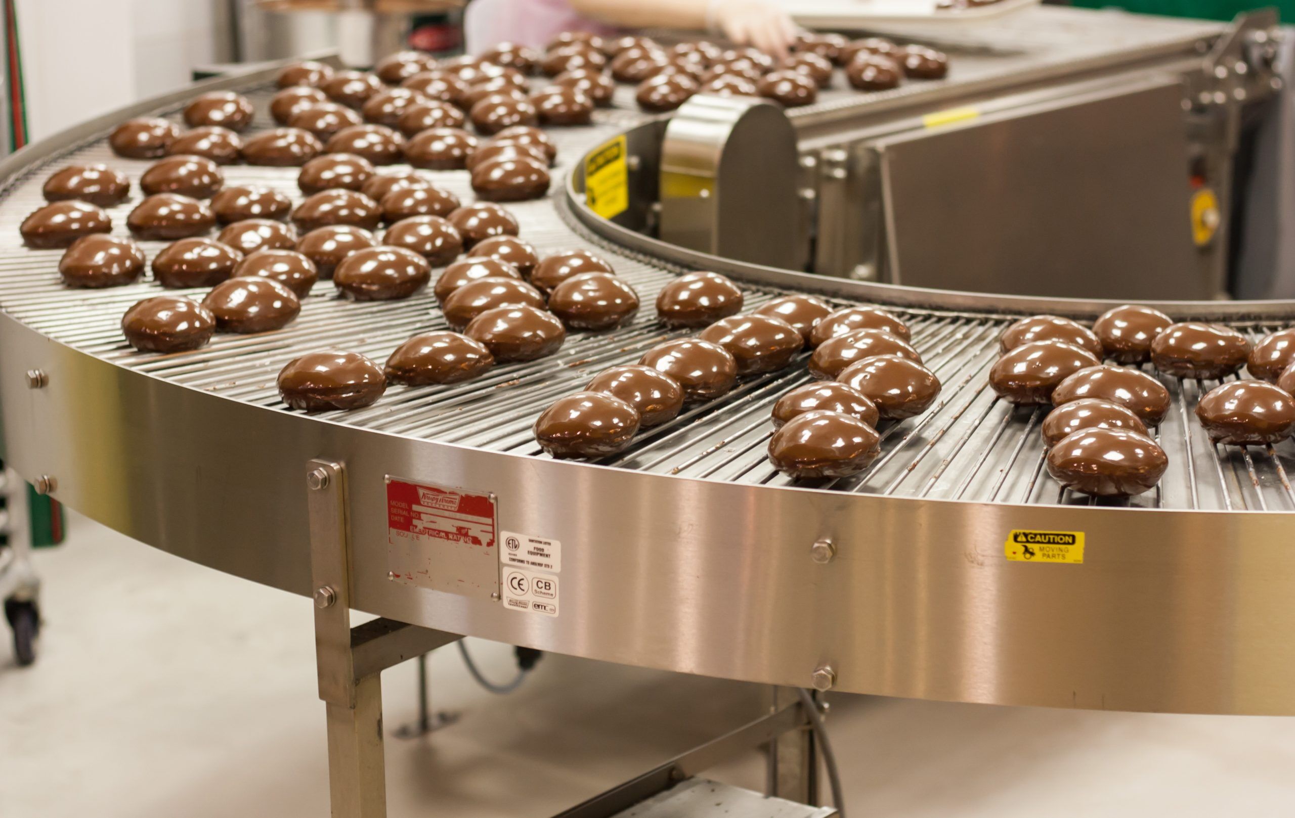 Ein Förderband transportiert mit Schokolade überzogene Pralinen und muss mit H1-Schmieröl von Völkel versorgt werden, um reibungslos zu funktionieren