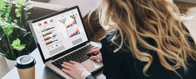 Frau mit langen Haaren sitzt am Laptop und tippt